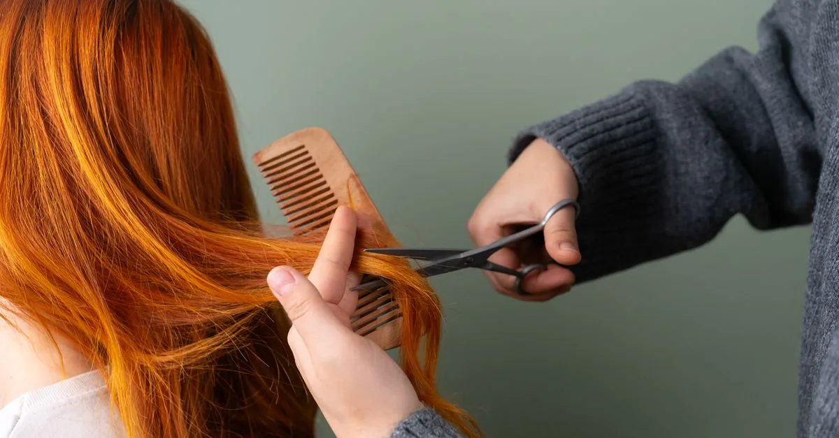 Symbolbild: Friseurin schneidet mit Schere und Kamm eine Haarpartie